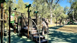 A playground with various play structures including a climbing area, slides, and swings. - Ray of Moon-Spacious getaway in PML near Yosemite + Kayaks + backup power (Groveland)