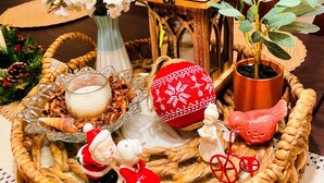A table with a woven tray holding a candle, a potted plant, a lantern, and a decorative Santa figurine. - Ray of Moon-Spacious getaway in PML near Yosemite + Kayaks + backup power (Groveland)