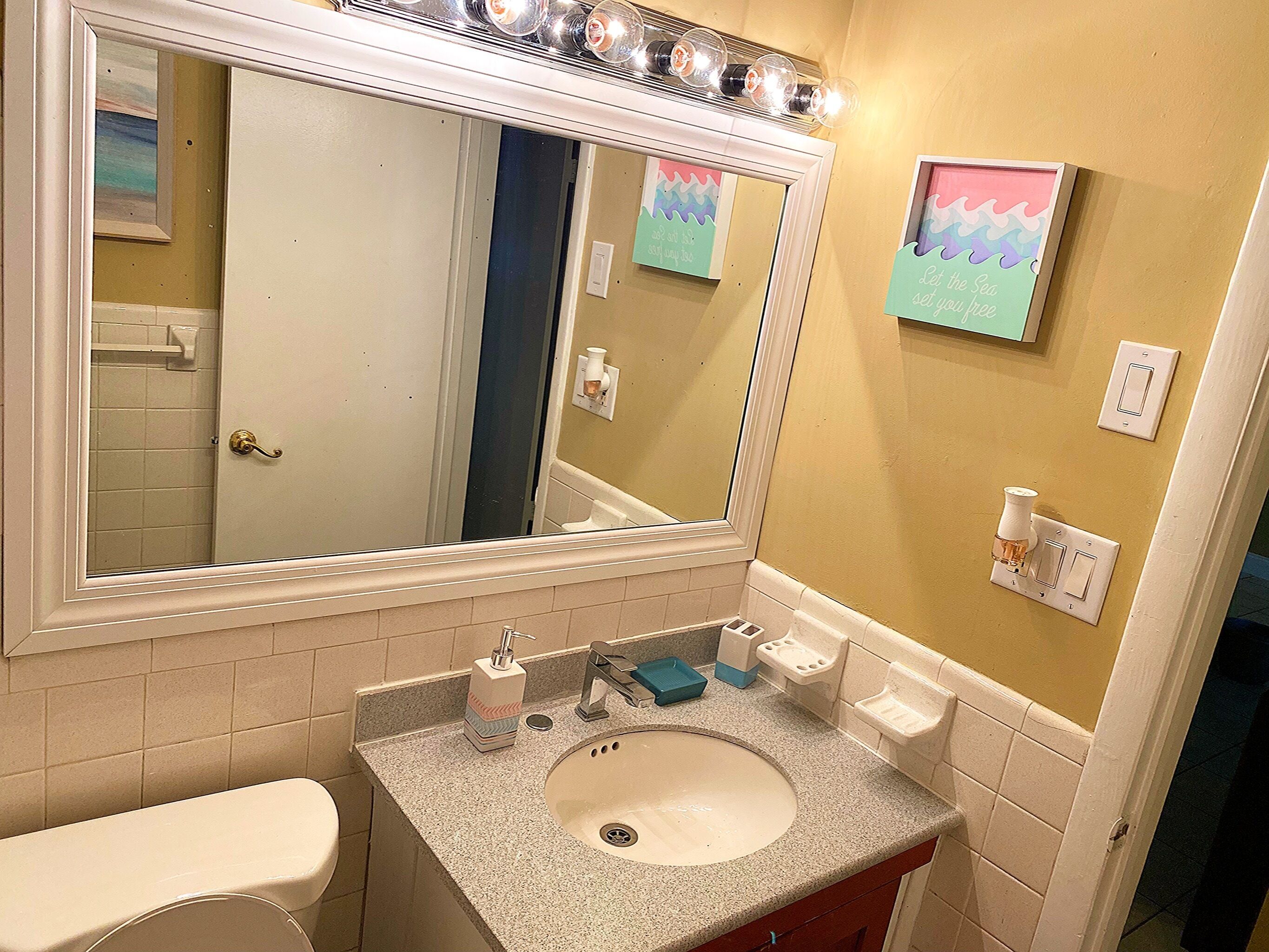 Een bad/douchecombinatie, een haardroger, handdoeken, zeep