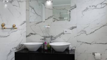 Un bagno con due lavabi, uno specchio e un mobile contenitore nero.