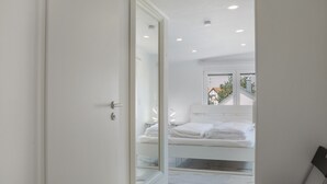 Ein modernes Badezimmer mit einer Duschkabine aus Glas, einer weißen Badewanne und einem großen Spiegel.