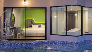 A modern hotel room with a glass partition, a bed, a seating area, and a bathroom. - Hotel Selene Chiang Rai (Chiang Rai)