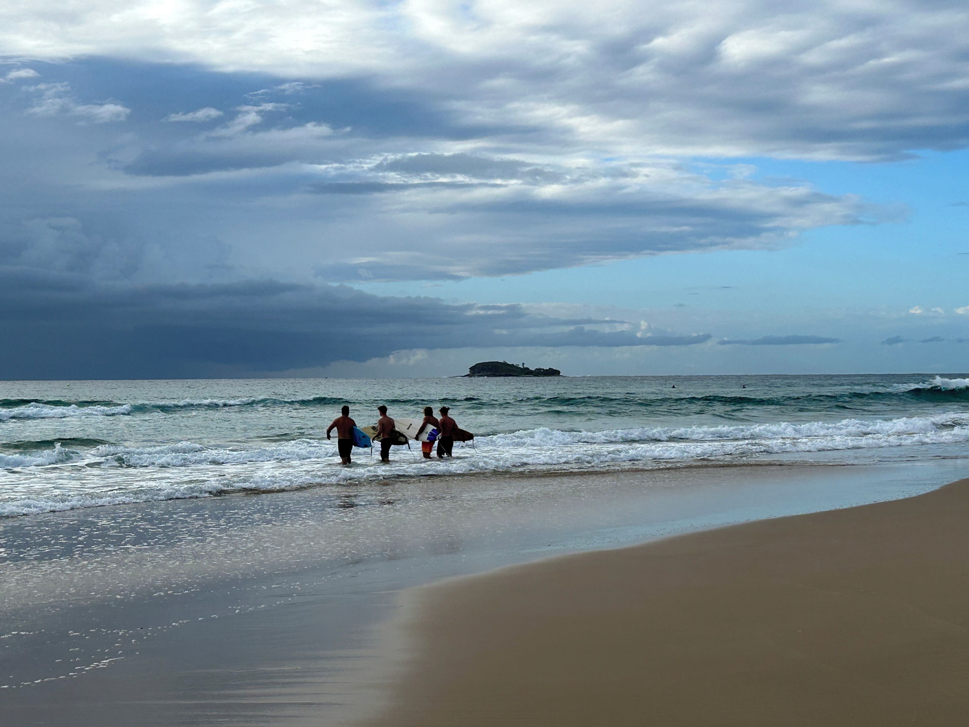 A beach with a sandy shore and waves.