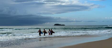 A beach with a sandy shore and waves.