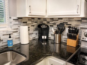A kitchen with white cabinets, a coffee maker, a knife block, and a bottle of hand soap. - Amazing Beds!-2 miles to Dollywood-The Island-Tanger (Sevierville)