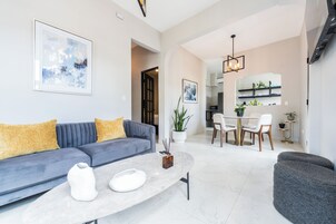 Una sala de estar moderna con sofá, mesa de centro y comedor.