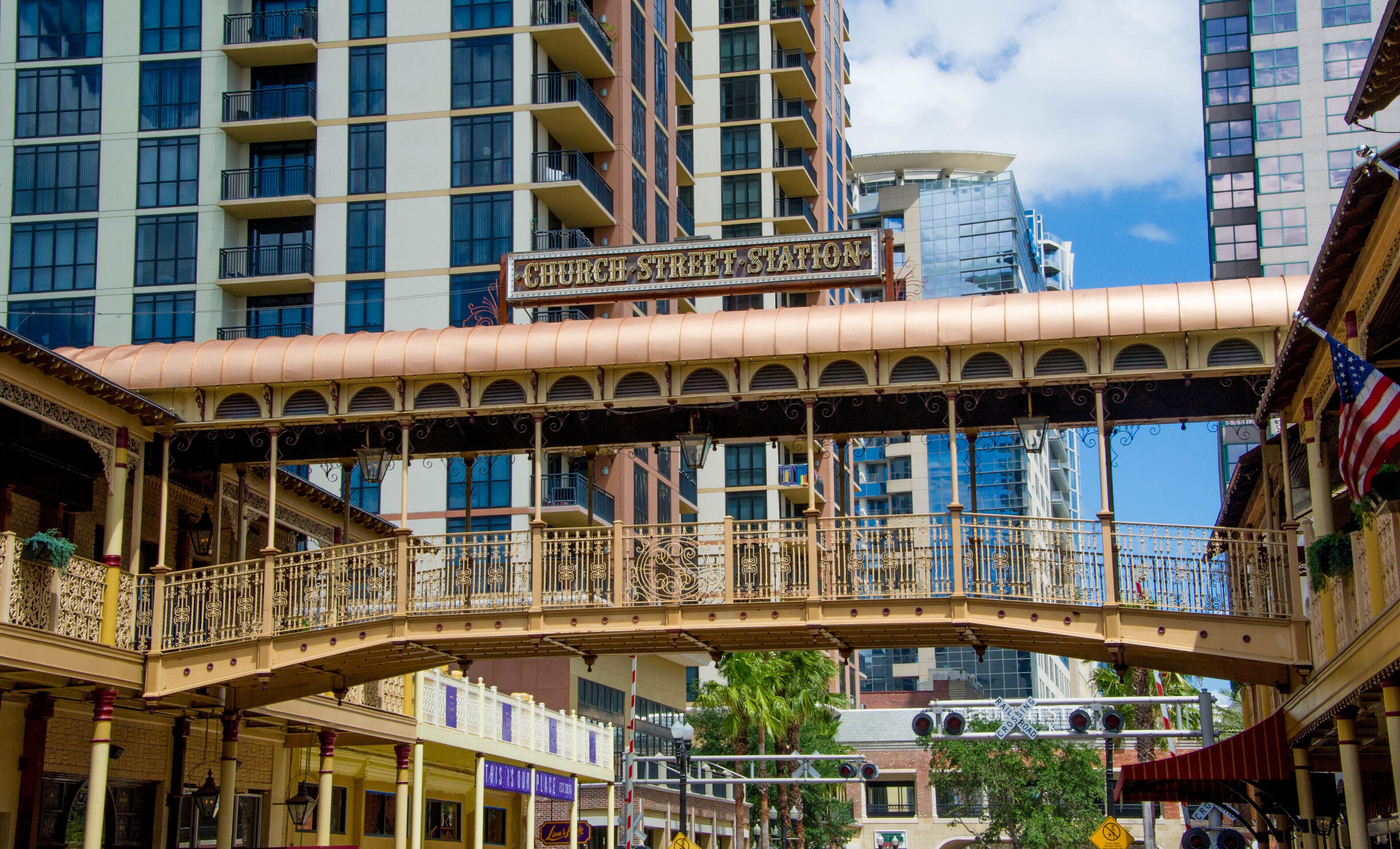 A covered pedestrian bridge with ornate railings and a sign reading "Church Street Station".
