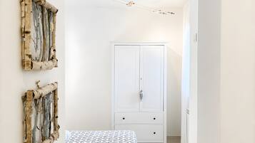 Ein Schlafzimmer mit einem Bett, einem Kleiderschrank und Wandbildern.