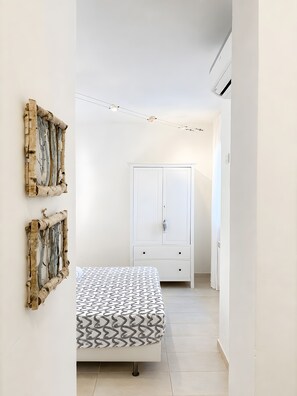 Ein Schlafzimmer mit einem Bett, einem Kleiderschrank und Wandbildern.