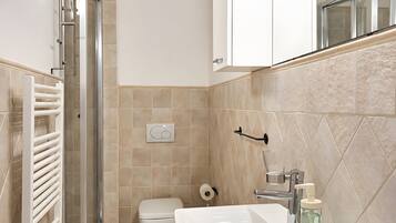 Un baño moderno con ducha, inodoro y lavabo.