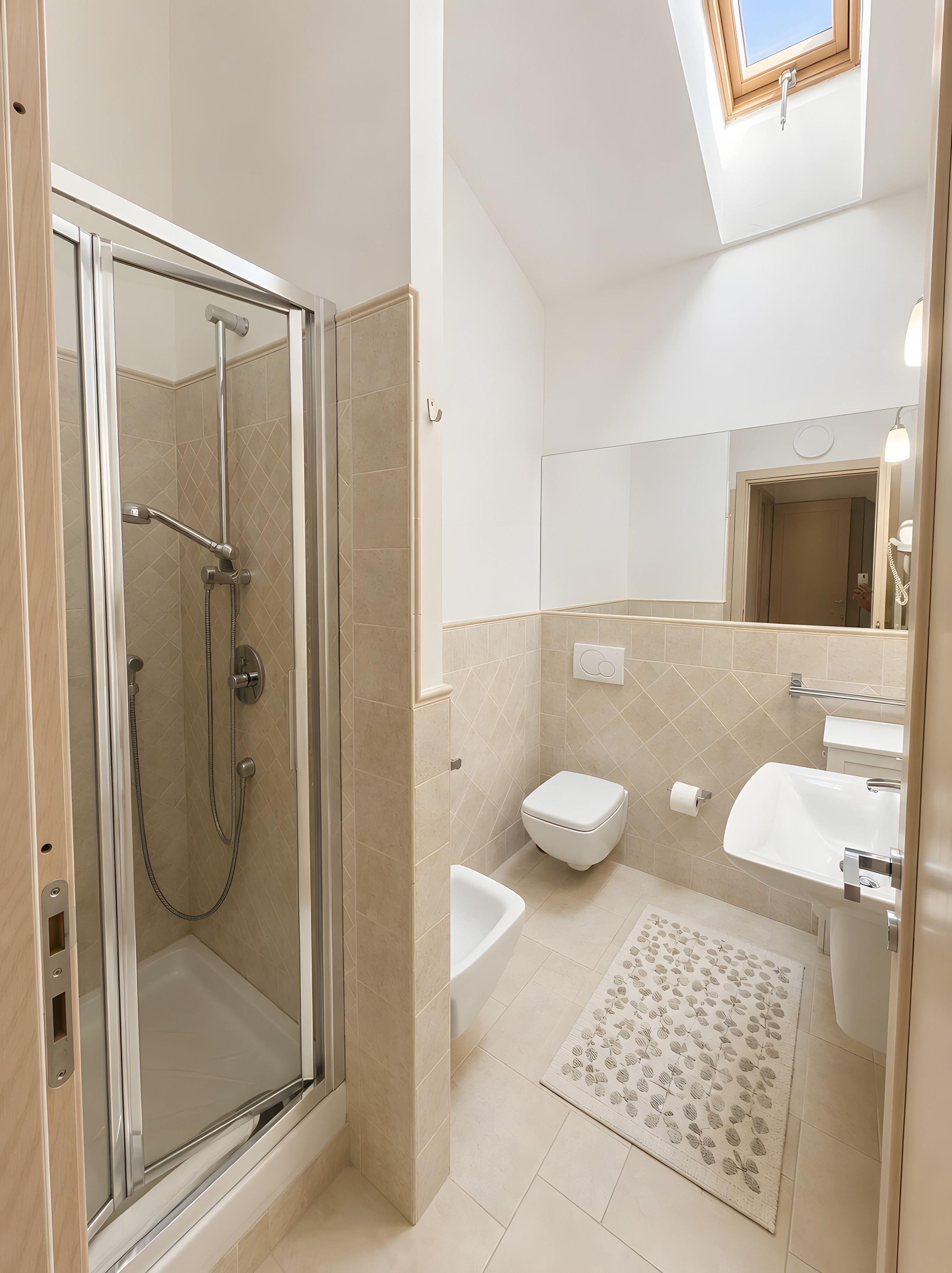 Un bagno moderno con cabina doccia in vetro, un WC bianco, un lavandino e uno specchio.