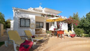 A white villa with a patio, outdoor seating, and a swimming pool. - Pet-friendly Casa da Alfarrobeira with Pool & Wi-Fi (Loulé)