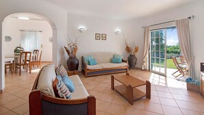 Ein Wohnzimmer mit einer Couch, einem Couchtisch und einem Essbereich mit Stühlen und einem Tisch.
