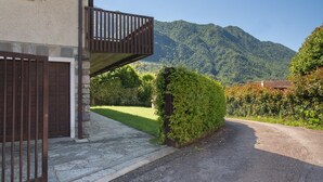 A building with a stone facade, a wooden balcony, and a view of a mountain.