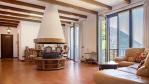 A spacious living area with a fireplace, a sofa, and a dining table.