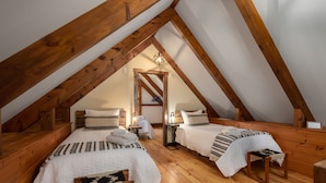 A cozy attic bedroom with two beds, wooden beams, and a sloped ceiling. - RIVER! Hot tub, Movie theater, Sauna, Massage chair (Conway)