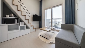 A modern living room with a staircase, a flat-screen TV, a coffee table, and a sofa. - Parkview Terrace Hotel (Paju)