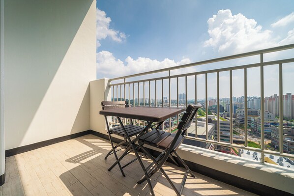 Un balcón con mesa y sillas, con vistas a la ciudad.