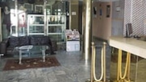 Eine moderne Hotelhalle mit Marmorboden, einer Couch, einem Couchtisch und einer Chandelier.