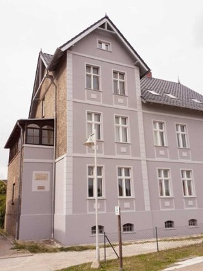 A multi-story building with a symmetrical facade, multiple windows, and a visible entrance.
