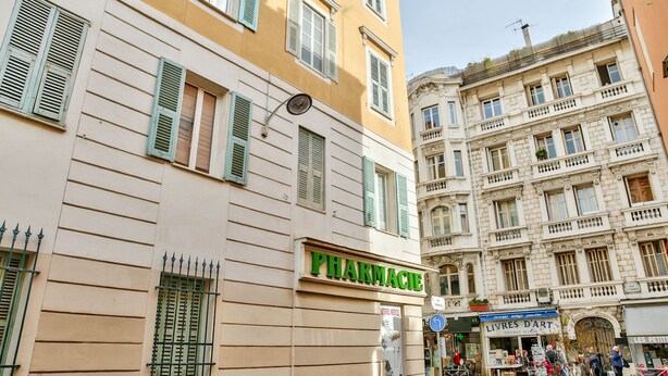 A building with a sign reading "PHARMACIE" and another sign for "LIVRES D'ART". - Co-ownership (Nice)