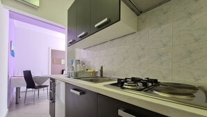 A modern kitchen with a gas stove, a sink, and a dining area with a table and chairs. - Apartment 2127/39650 (Istria - Rabac), 200m from the beach (Rabac)