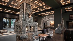 Un interior moderno con chimenea de piedra, zonas de estar y un diseño de techo único.