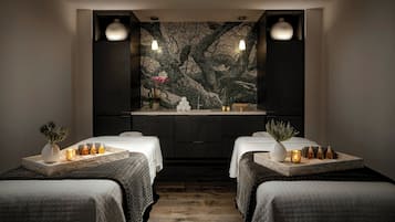 Relax in this serene spa room with two plush beds, a soothing mural, and a tranquil ambiance.