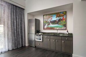 A modern kitchen with a stainless steel refrigerator, oven, and a marble countertop.