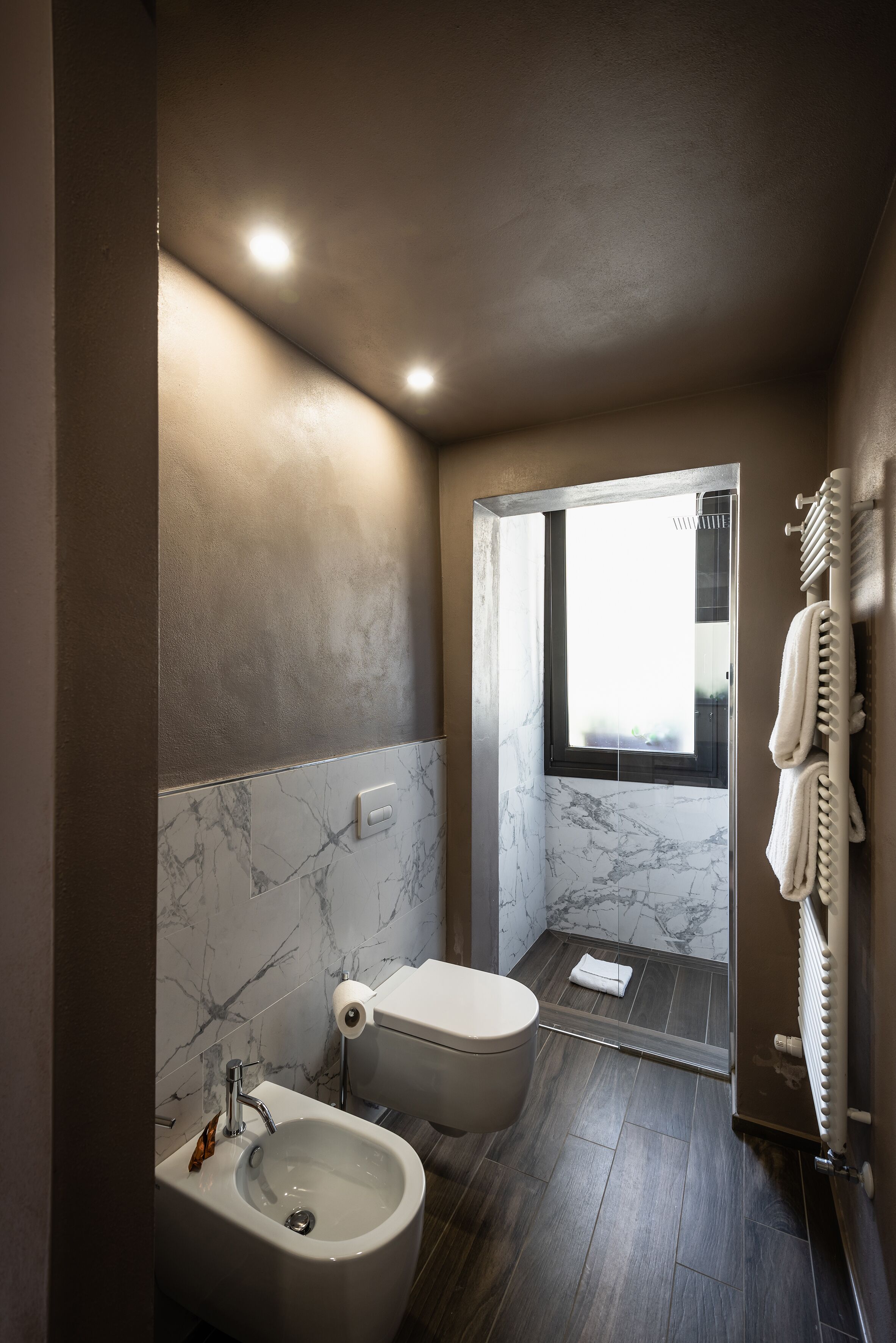 Un baño moderno con bidé, inodoro y cabina de ducha de vidrio.