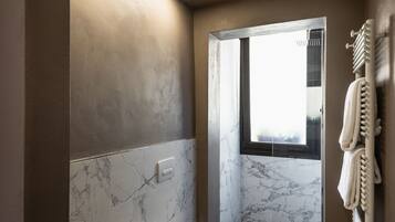 Un baño moderno con bidé, inodoro y cabina de ducha de vidrio.