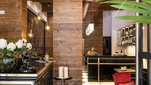 Un hall d’hôtel avec un sol à carreaux, un coin bar et un espace salon avec un fauteuil rouge.