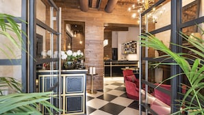 Un hall d’entrée avec un sol à carreaux, un comptoir de réception et un espace bar.