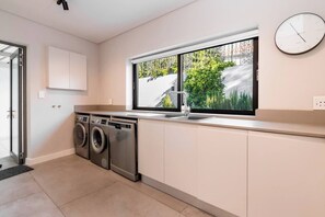 Eine moderne Küche mit integrierten Geräten, einem Fenster mit Ausblick und einer Wanduhr.