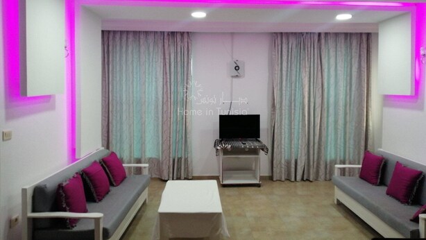 A living room with two grey sofas, a white coffee table, and a flat-screen TV on a stand. - APARTMENT IN HERGLA SEA VIEW (Hergla)