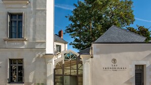 A building with a sign reading "LES TRÉSORIÈRES TOURS" and a glass entrance. - Les Trésorières (Tours)