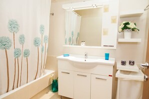 A bathroom with a white sink, mirror, and a shower curtain with a tree pattern. - Sifris Apartment in the Heart of Athens (Athens)