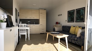 Un espace de vie compact comprenant un coin cuisine, un coin repas et un canapé avec des coussins.