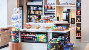 A grocery store interior with shelves stocked with snacks, beverages, and frozen goods.