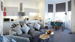 Een moderne keuken met witte kastjes, een ingebouwde kookplaat en een groot raam.