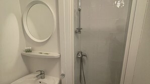 Un baño con lavamanos, espejo y ducha.