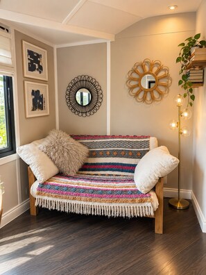 A room with a wooden bench, a mirror, and a floor lamp. - Secluded Lodge at the top of the garden. Free Parking, Dog Friendly £20 per pet (Brighton)