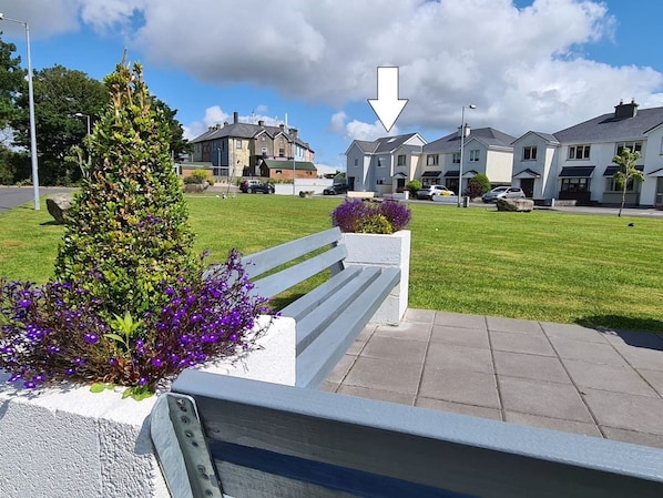 A residential area with houses, a bench, and a flower bed. - Bay Area House, Spiddal (Spiddal)