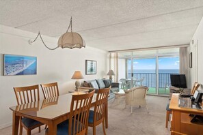 Relax in this spacious living area with a dining table, sofa, and ocean views.