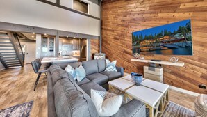 A modern interior with a wooden wall, a dining area, and a living room with a sofa and coffee table. - Stunning Lakefront Near Heavenly LLV611 (South Lake Tahoe)