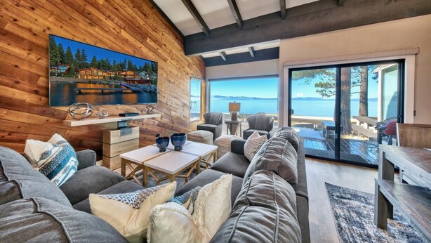A modern living room with a large TV, comfortable seating, and a scenic view of the water. - Stunning Lakefront Near Heavenly LLV611 (South Lake Tahoe)