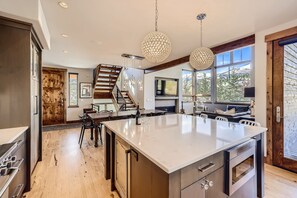 Enjoy a meal with a scenic mountain view from this kitchen, which features a large island and stainless steel appliances.