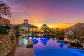 A pool area with a gazebo, palm trees, and a mountainous backdrop. - 6BR Casa Connie is Walking Distance to Pedregal City Center and fts. 2 Pools! (Los Cabos)