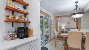Una cocina con estantes de madera, una cafetera y un tarro etiquetado con 'Coffee'.