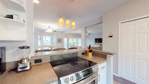 Une cuisine moderne dotée d’une cuisinière intégrée, d’un mixeur et d’un grand îlot central avec un évier.